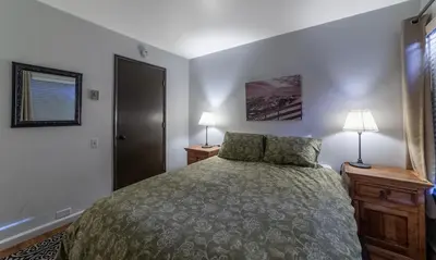 a bedroom with a bed and two lamps and a window at Adventure by Day Cozy Nights Family Alpine Condo in Mammoth Lakes