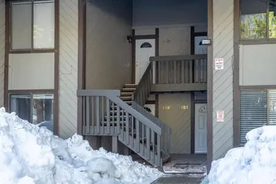 a house with snow on the ground in front of it at Adventure by Day Cozy Nights Family Alpine Condo in Mammoth Lakes