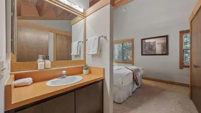a bathroom with a sink and a bed in a room at Unique Northstar Cabin w Fireplace Minutes to Skiing Trails and Town Alpine Bend by AvantStay in Truckee