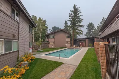 a swimming pool in a yard next to a house at Stylish Mammoth 1BR & Loft With Fireplace in Mammoth Lakes