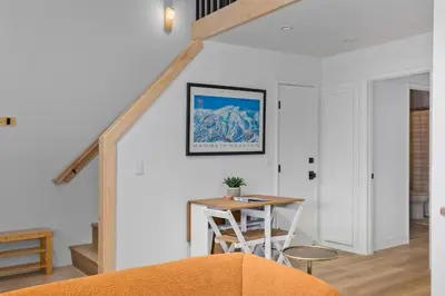 a room with a table and chairs and a staircase at Stylish Mammoth 1BR & Loft With Fireplace in Mammoth Lakes