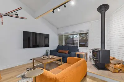 a living room with a blue couch and a fireplace at Stylish Mammoth 1BR & Loft With Fireplace in Mammoth Lakes