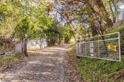 a gate on a dirt road next to a forest at Private Home,Ski HotTub,Firepit,Apple Hill,Tahoe in Placerville