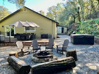 a backyard with chairs and a fire pit and a house at Private Home,Ski HotTub,Firepit,Apple Hill,Tahoe in Placerville