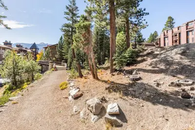 a dirt road with rocks and trees and a building at Val DIsere 27 in Mammoth Lakes