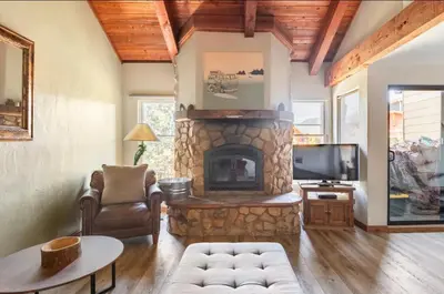 a living room with a stone fireplace and a tv at Val DIsere 27 in Mammoth Lakes