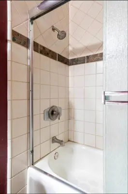 a bathroom with a tub with a shower at Treehouse at Canyon Lodge Walk to Slopes in Mammoth Lakes