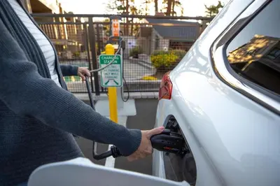 a person fueling a car at a parking meter at Treehouse at Canyon Lodge Walk to Slopes in Mammoth Lakes