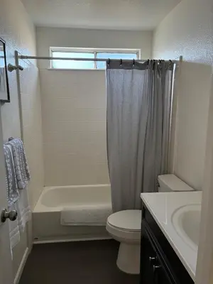 a bathroom with a shower and a toilet and a sink at Turlocks Little Palace in Turlock