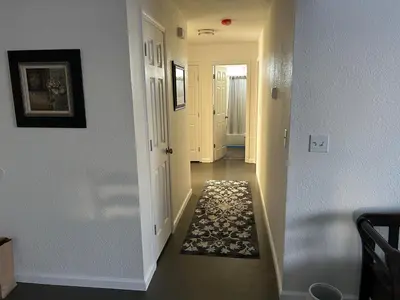 a hallway with a hallway leading into a room with a rug at Turlocks Little Palace in Turlock