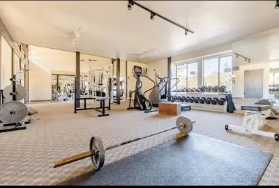 a gym with weights and exercise equipment in a room at Summit 107 in Mammoth Lakes