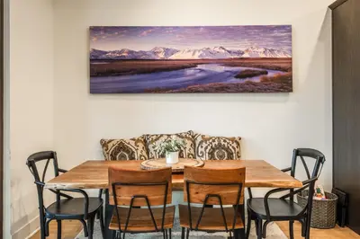 a dining room table with chairs and a painting on the wall at Mammoth Refuge Rustic Creekhouse Retreat in Mammoth Lakes