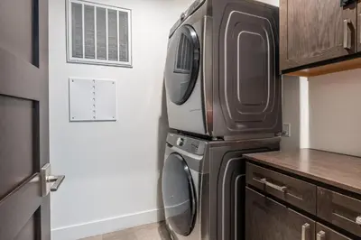 a kitchen with a washer and dryer next to a door at Mammoth Refuge Rustic Creekhouse Retreat in Mammoth Lakes