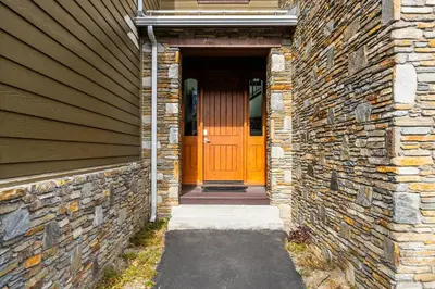 an entrance to a brick house with a wooden door at Mammoth Refuge Rustic Creekhouse Retreat in Mammoth Lakes
