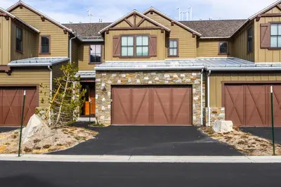 a house with two garage doors on a street at Mammoth Refuge Rustic Creekhouse Retreat in Mammoth Lakes