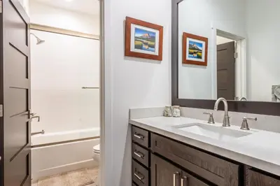 a bathroom with a sink and a toilet and a mirror at Mammoth Refuge Rustic Creekhouse Retreat in Mammoth Lakes