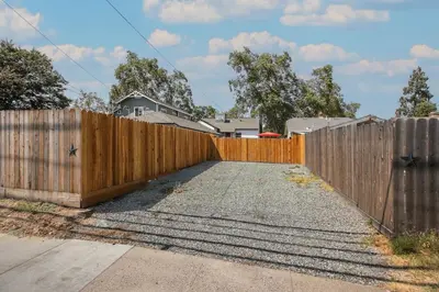a wooden fence in front of a driveway at Pet-Friendly Private Cottage In Tahoe Park in Sacramento