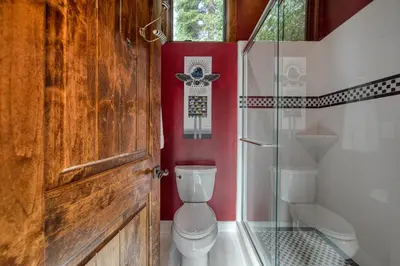 a bathroom with a toilet and a glass door at Painted River Retreat by Tahoe Getaways - 4BR w River Views, Hot Tub & EV Charger. in Truckee