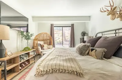 a bedroom with a bed and a chair and a window at Hidden Valley 33 in Mammoth Lakes