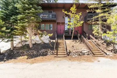 a house with a red door and some trees at Mammoth Estates 233 in Mammoth Lakes