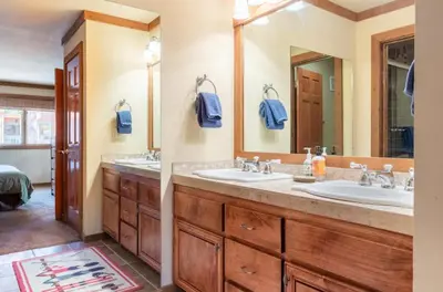 a bathroom with two sinks and a large mirror at Alpine Glow Escape Big Windows & Views! in Mammoth Lakes