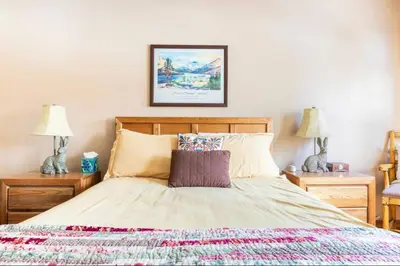 a bedroom with a bed with two night stands and two lamps at Alpine Glow Escape Big Windows & Views! in Mammoth Lakes