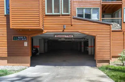 a building with a parking garage underneath it at Alpine Glow Escape Big Windows & Views! in Mammoth Lakes