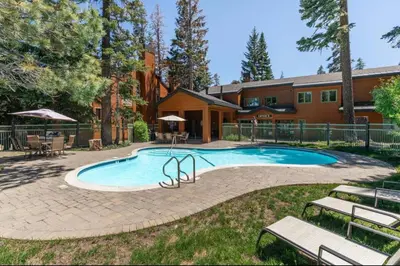 a swimming pool in a yard next to a house at Alpine Glow Escape Big Windows & Views! in Mammoth Lakes