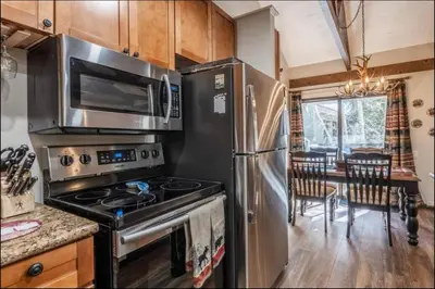 a kitchen with a stainless steel refrigerator and a stove at Seasons Four 110 in Mammoth Lakes