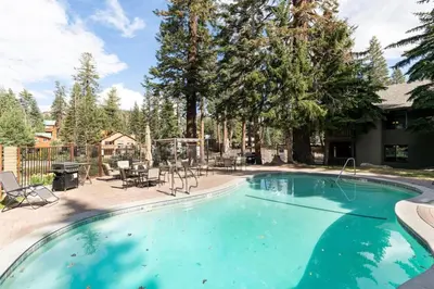 a swimming pool in a yard with chairs and trees at Seasons Four 110 in Mammoth Lakes