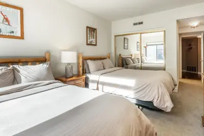 a bedroom with two beds and a mirror at Silver Bear 32 in Mammoth Lakes