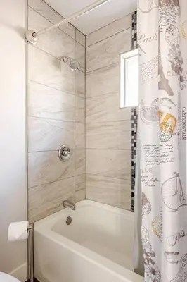 a white bath tub with a shower curtain in a bathroom at 719 Mid-Town Retreat in Reno
