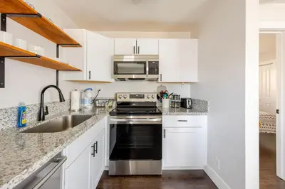 a kitchen with white cabinets and a black stove top oven at 719 Mid-Town Retreat in Reno