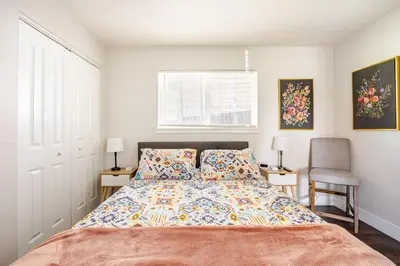 a bedroom with a bed and two chairs and a window at 721 Cozy Mid-Town Hideaway in Reno