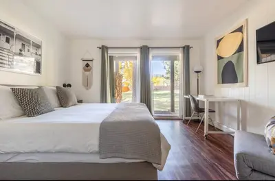 a bedroom with a large white bed and a desk at Chateau Blanc 21 in Mammoth Lakes