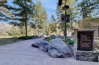 a sign in a park with rocks on the sidewalk at Palisades Tahoe Ski Getaway with Pool and Lift Access! in Olympic Valley