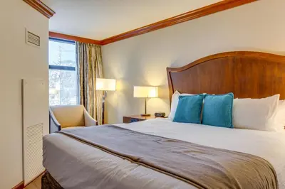 a hotel room with a large bed with blue pillows at Palisades Tahoe Ski Getaway with Pool and Lift Access! in Olympic Valley