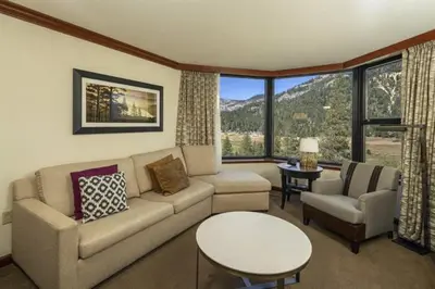 a living room with a couch and a table at Walk to Palisades Tahoe Ski Lifts Mtn-View Condo in Olympic Valley