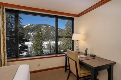 a bedroom with a desk and a window with a mountain view at Walk to Palisades Tahoe Ski Lifts Mtn-View Condo in Olympic Valley