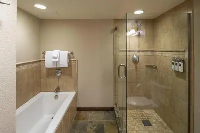 a bathroom with a tub and a glass shower at Walk to Palisades Tahoe Ski Lifts Mtn-View Condo in Olympic Valley