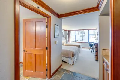 a room with a door leading to a bedroom with a bed at Ski-InandSki-Out! 2BR Resort Condo with Pool, Hot Tub in Olympic Valley