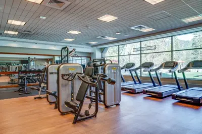 a gym with rows of treadmills and elliptical machines at Ski-InandSki-Out! 2BR Resort Condo with Pool, Hot Tub in Olympic Valley