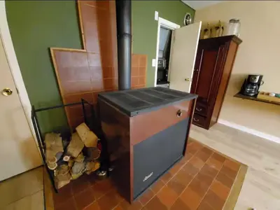 a kitchen with a stove with a pile of wood at Cozy Room in Rural Markleeville Cabin in Markleeville