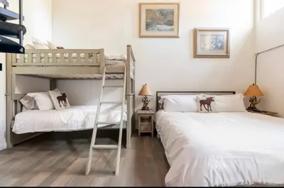 two bunk beds in a room with a ladder at St. Moritz 39 in Mammoth Lakes