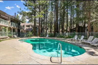 a swimming pool in a yard with chairs and trees at St. Moritz 39 in Mammoth Lakes