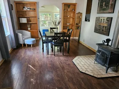 a dining room with a table and a wood stove at Amador Wine Country Cottage in Fiddletown