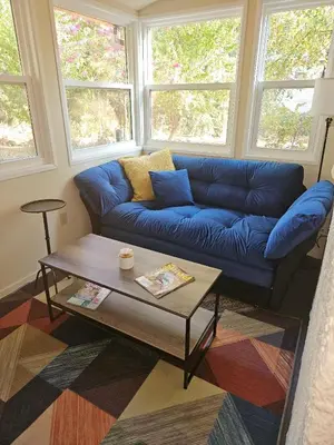 a living room with a blue couch and a coffee table at Amador Wine Country Cottage in Fiddletown