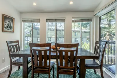 a dining room with a table and chairs and windows at Chateau Blanc 1 in Mammoth Lakes