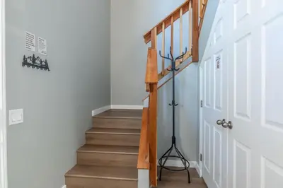 a staircase in a home with white walls and wooden stairs at Chateau Blanc 1 in Mammoth Lakes