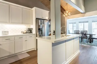 a kitchen with white cabinets and a dining room at Chateau Blanc 1 in Mammoth Lakes